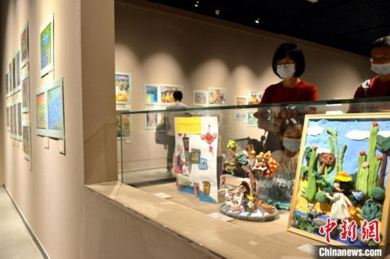 图为家长带着孩子参观展览。　吕明 摄