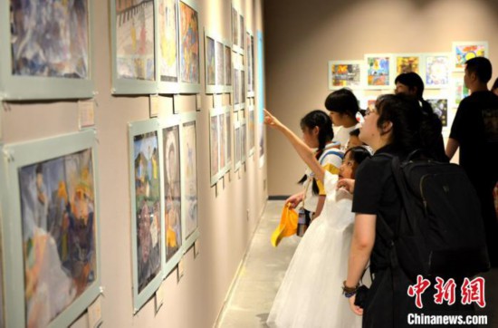 图为家长带着孩子参观展览。　吕明 摄