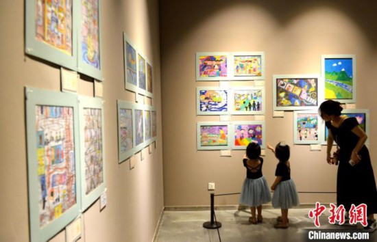 图为家长带着孩子参观展览。　吕明 摄
