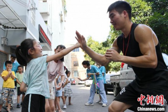 图为大学生志愿者在组织孩子们参加体育健身活动。　廖光福 摄