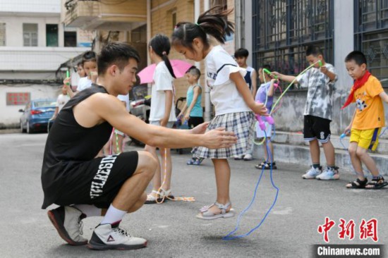 圖為大學生志愿者在教孩子們學跳繩。廖光福 攝