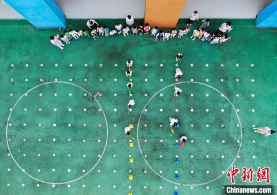 在肥西縣山南鎮中心幼兒園，孩子們在玩滾鐵環游戲。(無人機照片) 陳家樂 攝