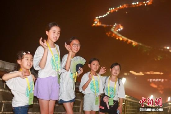 8月9日晚，2023海外华裔青少年夏季研学营的学员们夜游八达岭长城。图为学员们在长城上拍照。<a target='_blank' href='http://edu.people.com.cn/'><p  align=