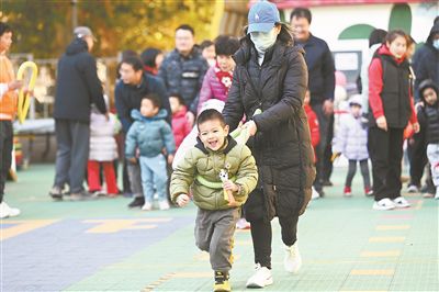 在北京市东城区欣苑幼儿园举办的“冬日暖阳 乐享运动”亲子运动会上，家长陪伴孩子共同体验运动的快乐，家校联手呵护孩子健康成长。 新华社记者 金良快摄