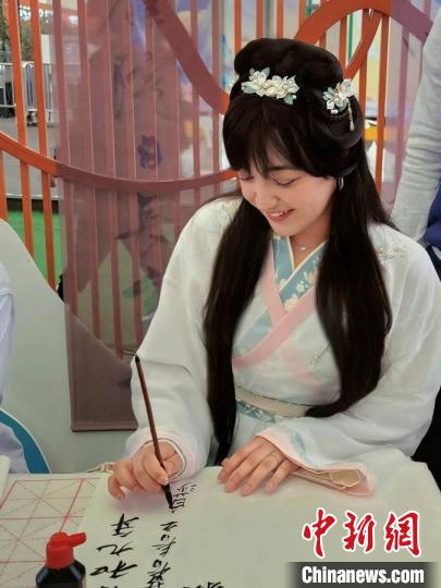 4月13日，白莎在2024年“中國華服周·滬上繁花”活動現場體驗寫毛筆字。(受訪者供圖)