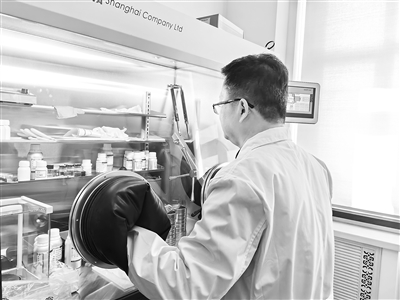 图为哈尔滨工程大学王贵领西宾正在用提纯的球形石墨拼装锂离子电板。受访者供图