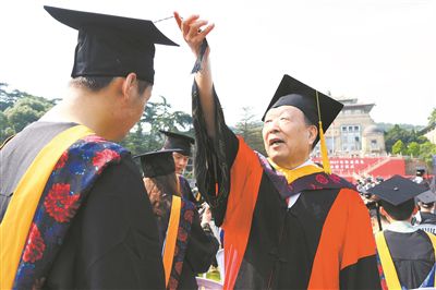 2017年6月22日，李德仁（右一）參加武漢大學畢業典禮並為畢業生撥穗。