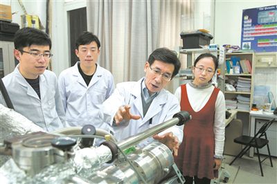 2017年10月，清华大学低维量子物理国家重点实验室，薛其坤（左三）与学生讨论实验工作。 苑洁摄