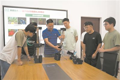 張喜瑞（左三）向學生講解智能仿形割膠機的設計原理。 受訪者供圖