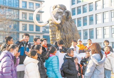 圖為科研人員為學生講解科學家“復活”猛犸象的最新進展。張進剛攝