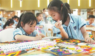 圖為小朋友在制作紙鳶。本報記者 何亮攝