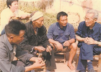 侯光炯（右一）和農民在一起親切交流。 西南大學檔案館供圖