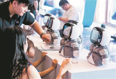 在第三屆軟件創新發展大會上，一名小女孩與陪伴機器人互動。中新社記者 張暢攝