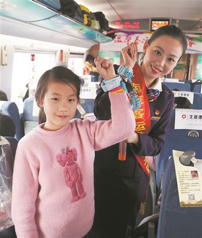 列車工作人員和小乘客展示防走失兒童專用手環。