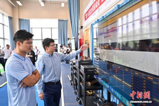 图为苏炳添在训练基地内了解数字化跑道分析系统配资公司有哪些。中新社记者 陈骥旻 摄